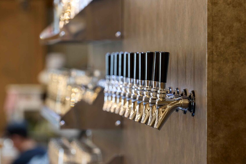 A row of beer taps mounted on a wall. 4