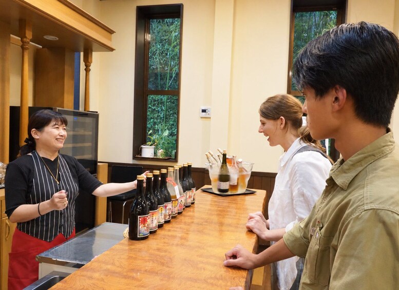 Un bar avec des bouteilles de boissons et un serveur. 2