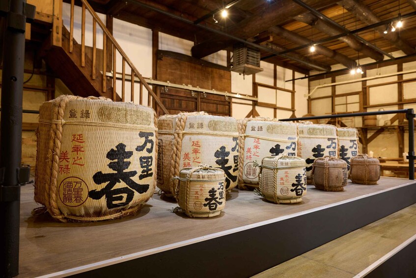 Large sacks of rice with Japanese characters on a wooden shelf in a warehouse. 1
