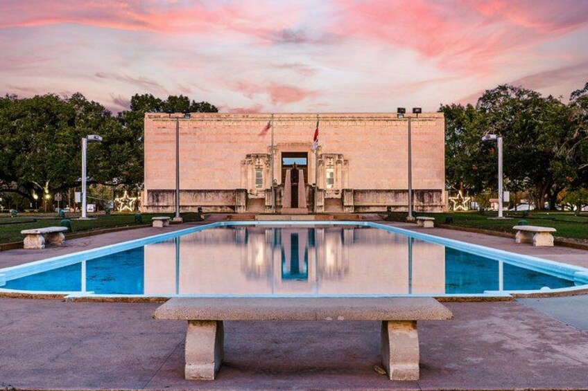 A building with a pool in front, surrounded by trees and a clear sky. 4