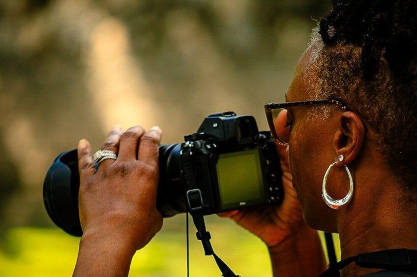 A person holding a camera, wearing a ring, and an earring. 3