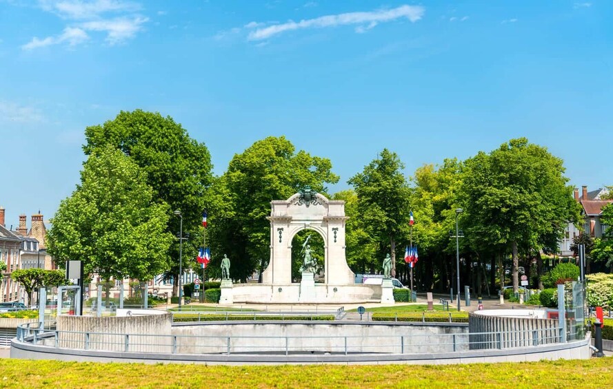 Un parc avec un monument central, entouré d’arbres et sous un ciel dégagé. 3