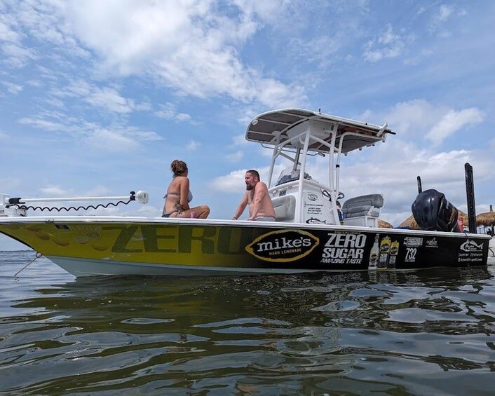 A boat with people on it, a clear sky, and calm water. 2