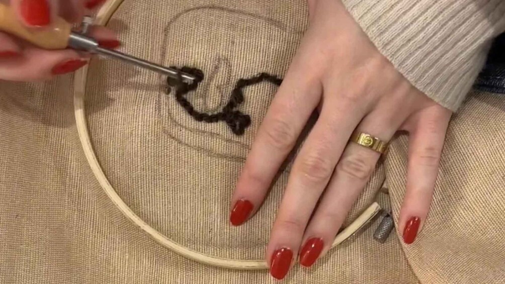 A person embroidering on fabric with a needle and thread. 1