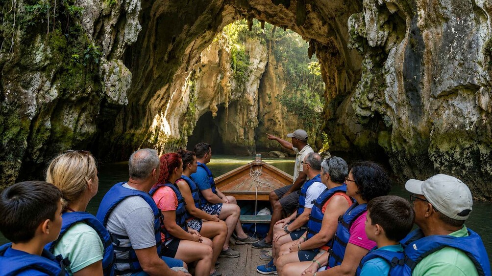 Eine Gruppe von Menschen in einem Boot in einer Höhle mit Stalaktiten. 1