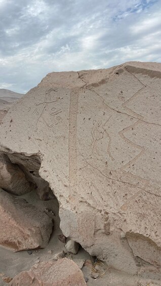 A large rock formation with visible erosion patterns and a cloudy sky. 4