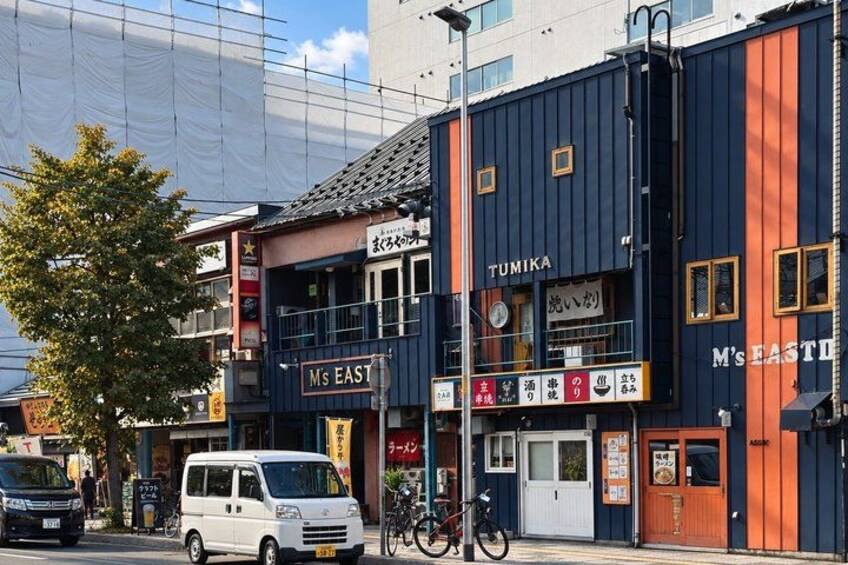 A street with buildings, a white van, and a bicycle. 5