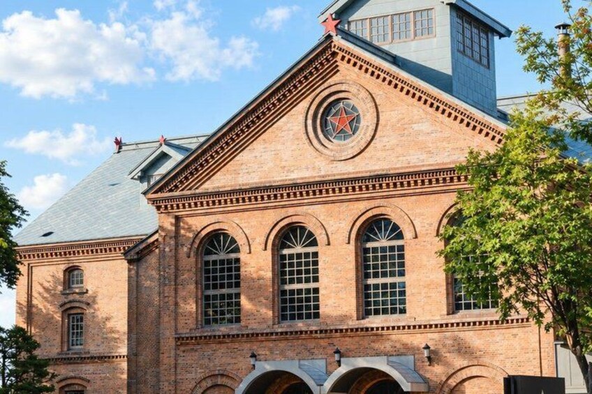 A brick building with a star emblem, arched windows, and a clock tower. 2