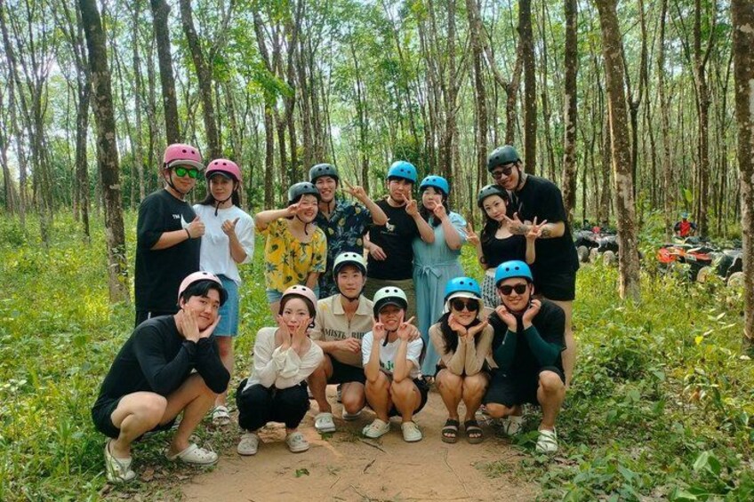 A group of people in a forested area with trees and a dirt path. 3
