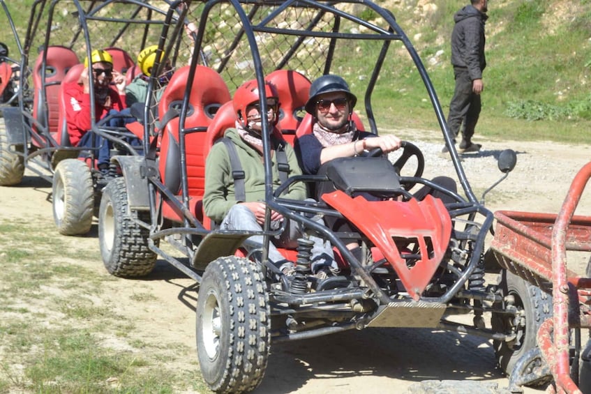 A group of people in off-road vehicles on a dirt path. 2