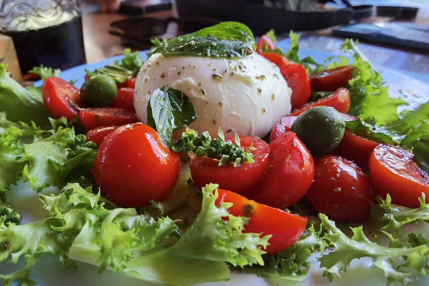 Ensalada con un albondón de queso blanco, tomates cherry, aceitunas y lechuga. 4