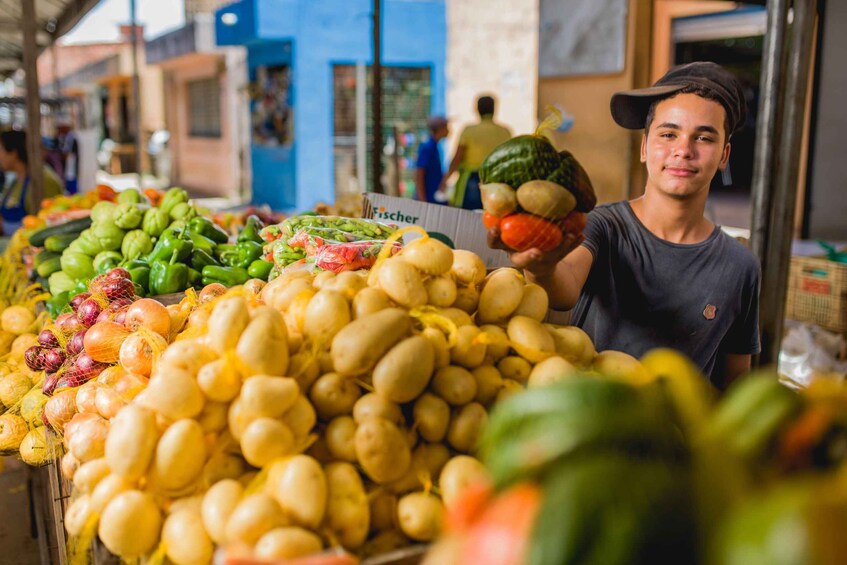 A market stall with various vegetables like potatoes, green peppers, and onions. 3