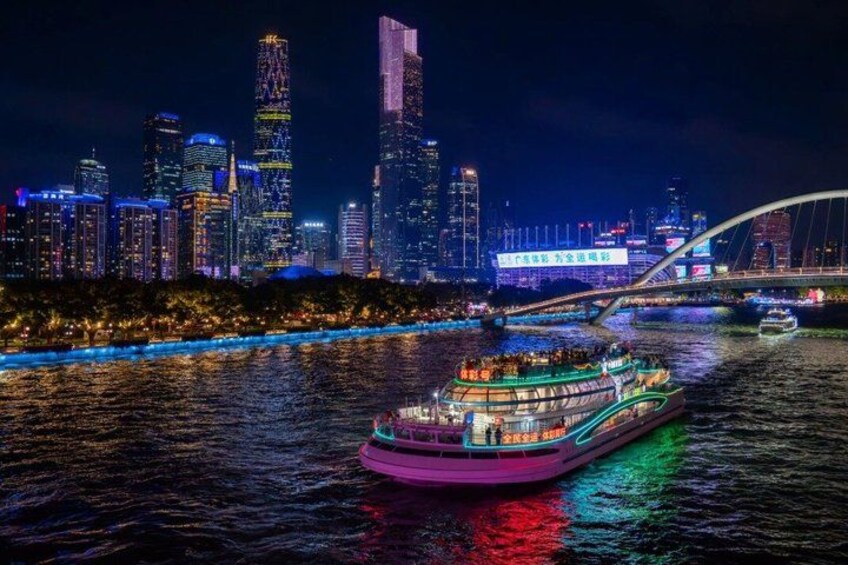 Ein Fluss mit einem hell beleuchteten Boot, einer Skyline mit beleuchteten Gebäuden und einer Brücke im Hintergrund. 5
