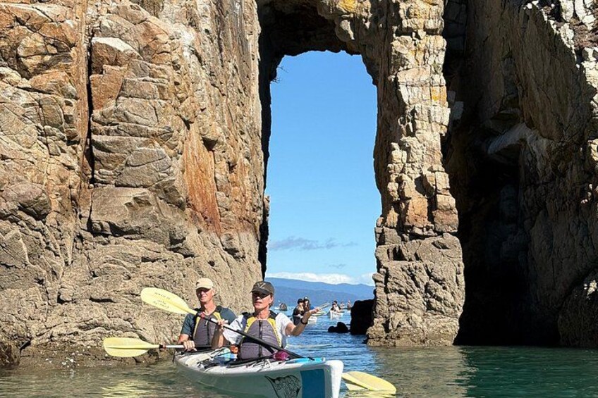 Kayakers in a narrow waterway between rocky cliffs. 3