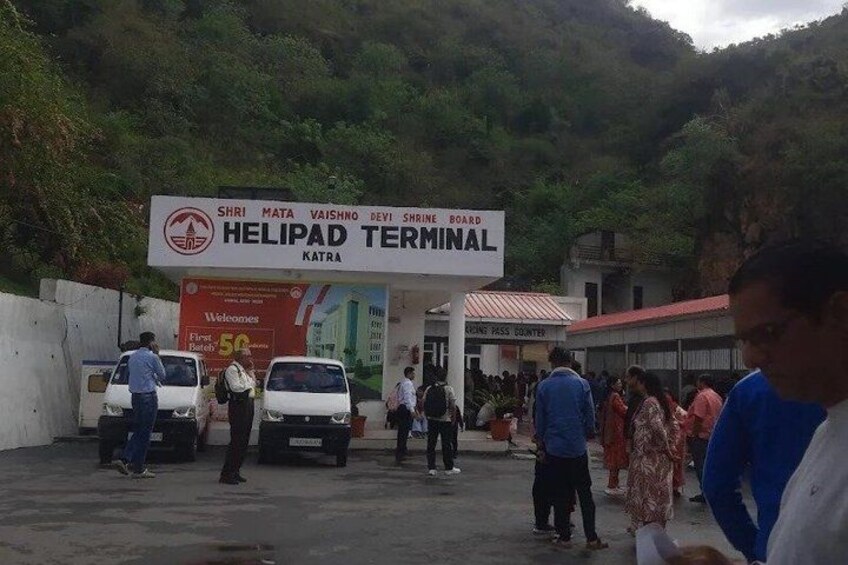 A Helipad Terminal with a signboard, a fuel counter, and several people and vehicles. 3