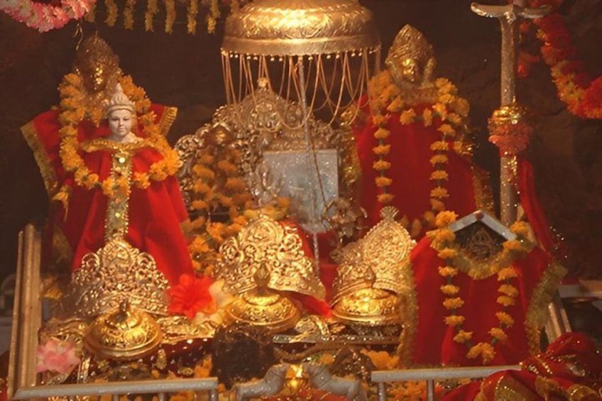 A temple with ornate golden decorations and red drapery. 1