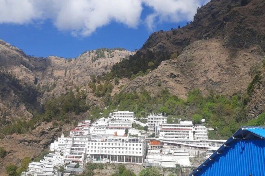 A monastery complex nestled in a mountainous area with rocky terrain and greenery. 4