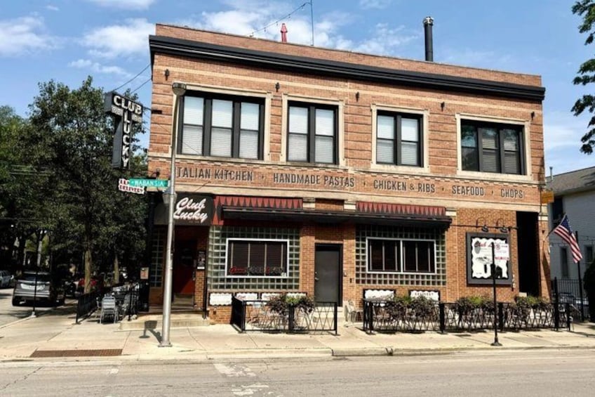 A brick building with a sign for 'Club Lucky' and 'Italian Kitchen'. 2