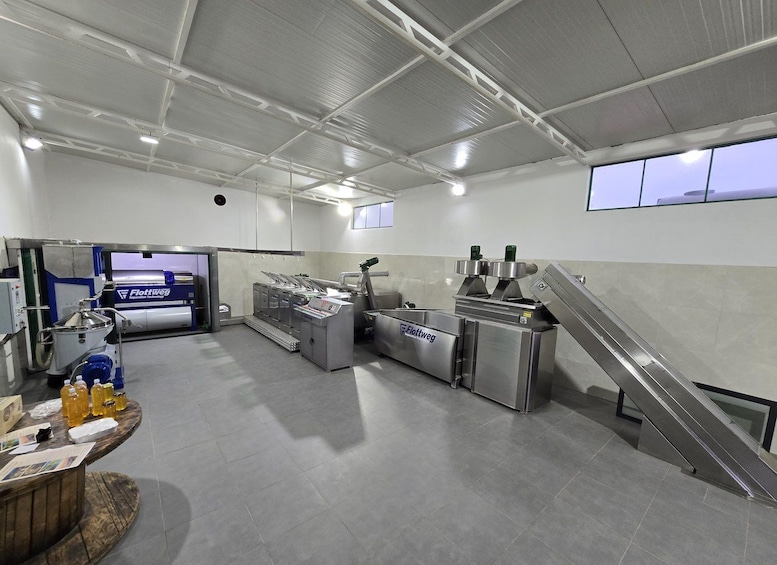 A commercial kitchen with industrial equipment, a wooden counter with bottles, and an escalator. 3
