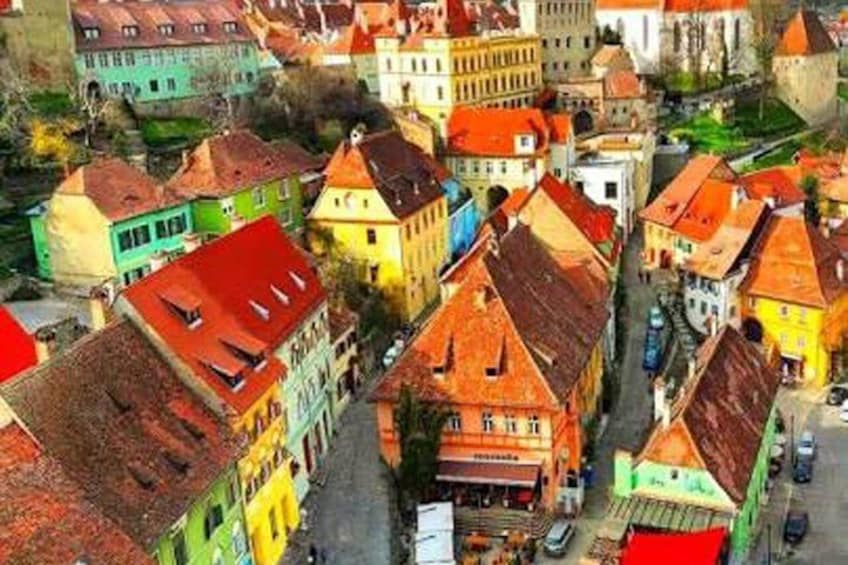 A colorful street with historic buildings and a prominent church. 2