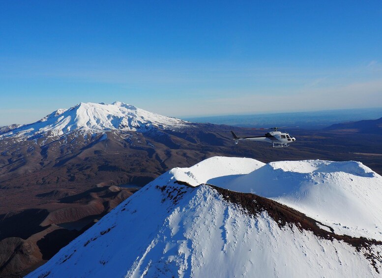 Un hélicoptère survole une chaîne de montagnes enneigées. 4