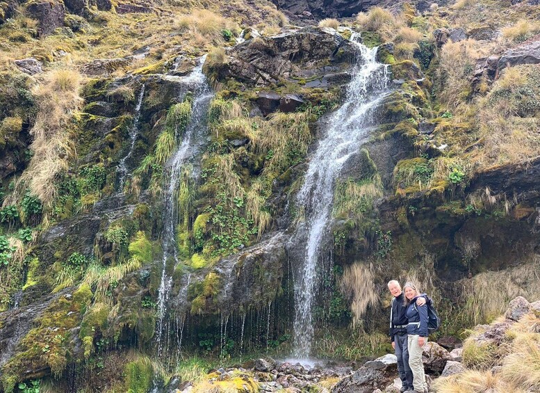 A waterfall cascading down a rocky cliff surrounded by greenery. 4