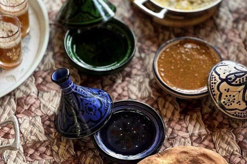 A variety of Moroccan tea and spice containers on a woven tablecloth. 2