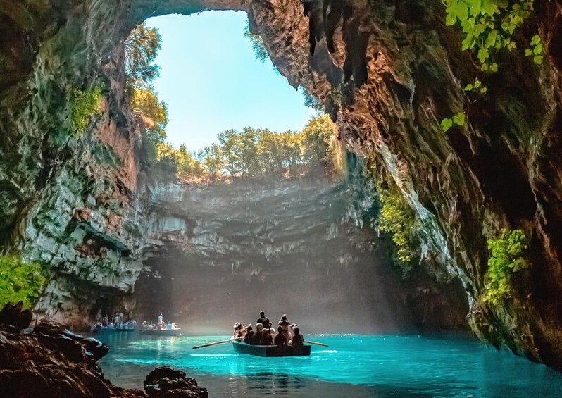 Une excursion en bateau à travers une formation naturelle de grottes, avec une eau d’un bleu cristallin et une végétation luxuriante tout autour. 1