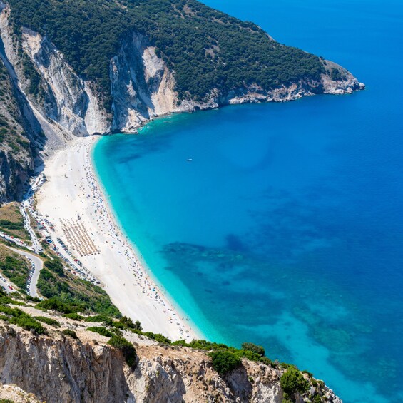Un paysage côtier avec une plage, des falaises et une eau d’un bleu limpide. 3