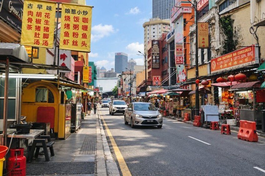 A street with shops, a car, and a pedestrian walkway. 4