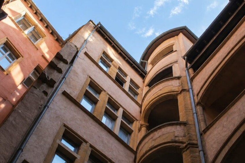 A multi-story building with arched windows and a corner entrance. 3