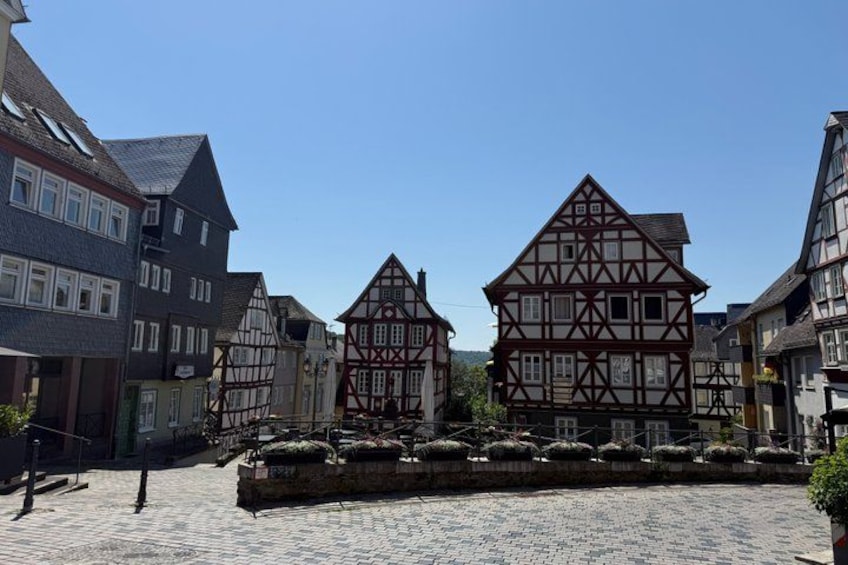 A cobblestone street with traditional half-timbered houses. 4