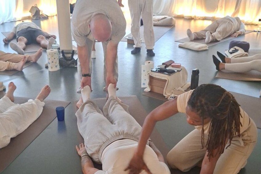 A group of people in a yoga class, some on mats and others standing. 2