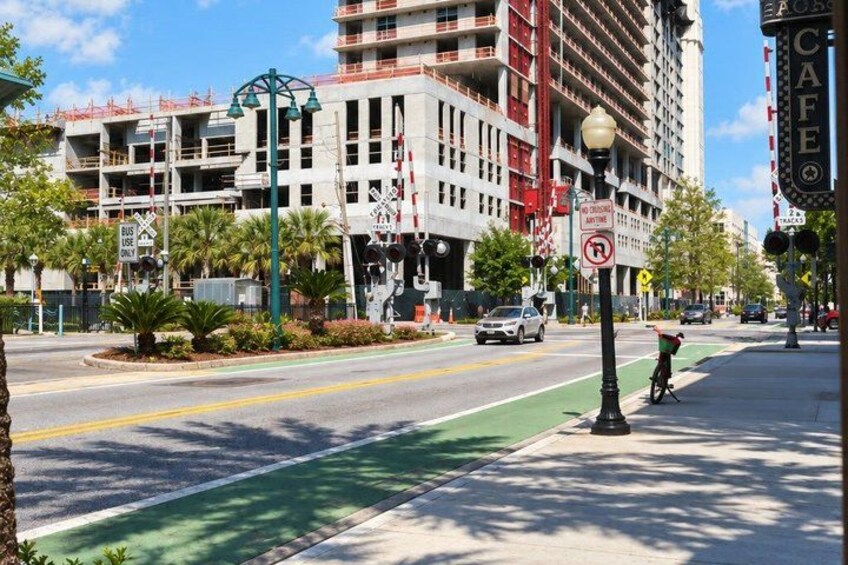 A street with a green bike lane, a bus stop, and a building under construction. 4