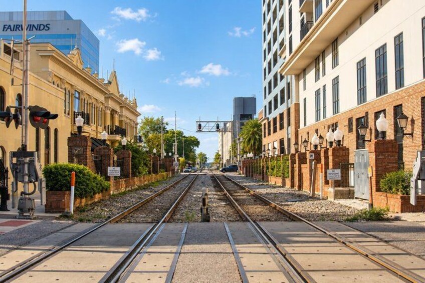 A railway track with a train in the distance, surrounded by buildings and greenery. 2