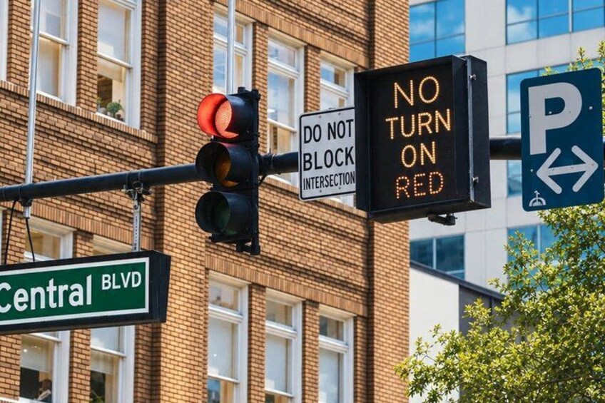 A traffic light, a 'NO TURN ON RED' sign, a 'DO NOT BLOCK INTERSECTION' sign, and a parking sign on Central Blvd. 5