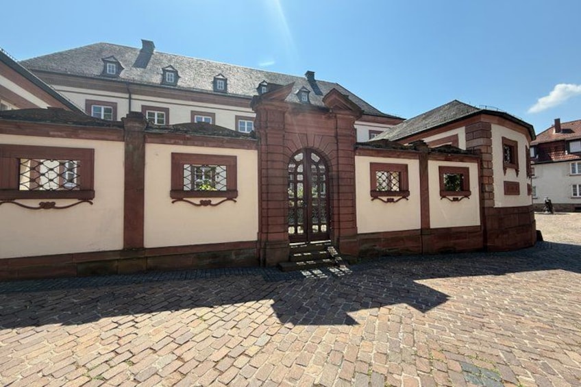 A historic building with a brick gate, arched entrance, and decorative window frames. 2