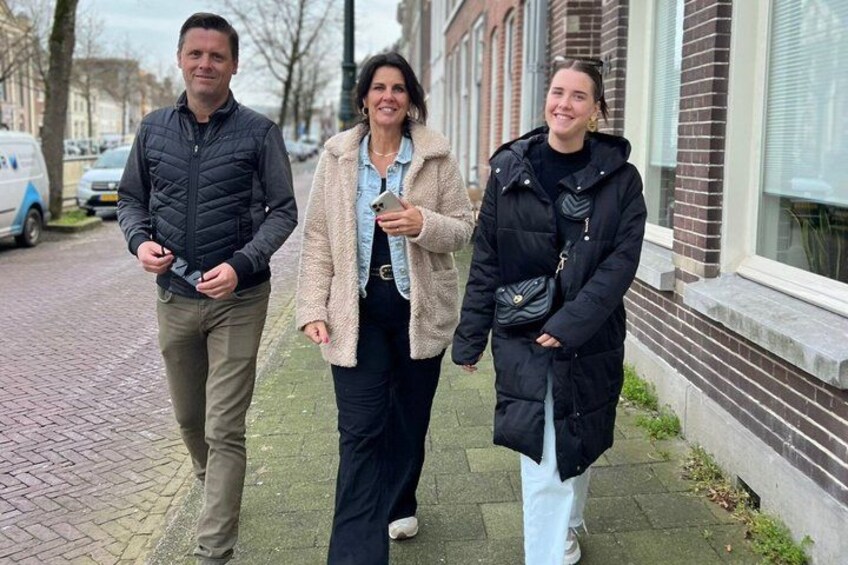 Three people walking on a sidewalk. 3