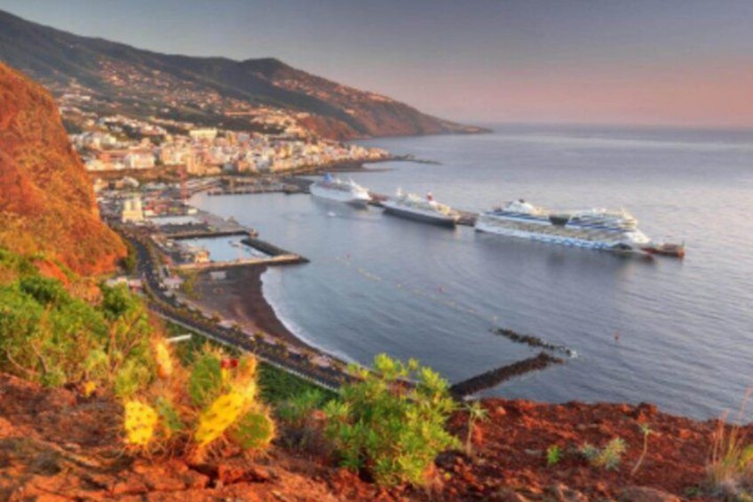 A coastal town with a harbor, boats, and a mountainous backdrop. 5