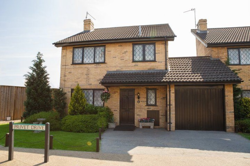 A two-story house with a tiled roof, a front garage, and a well-maintained lawn. 4