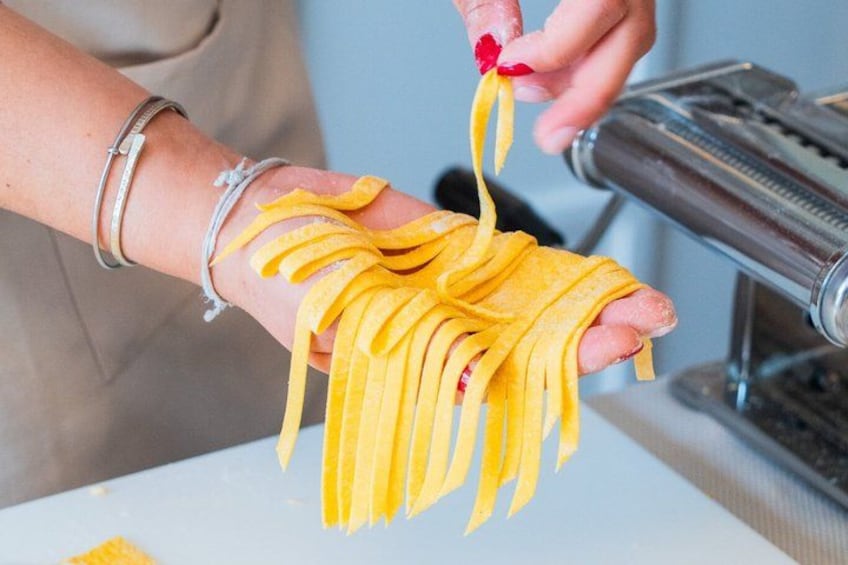 A person holding a bunch of yellow pasta. 3