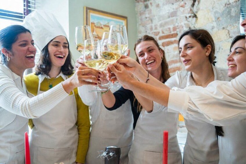 A group of people toasting with champagne glasses in a brick-walled room. 5