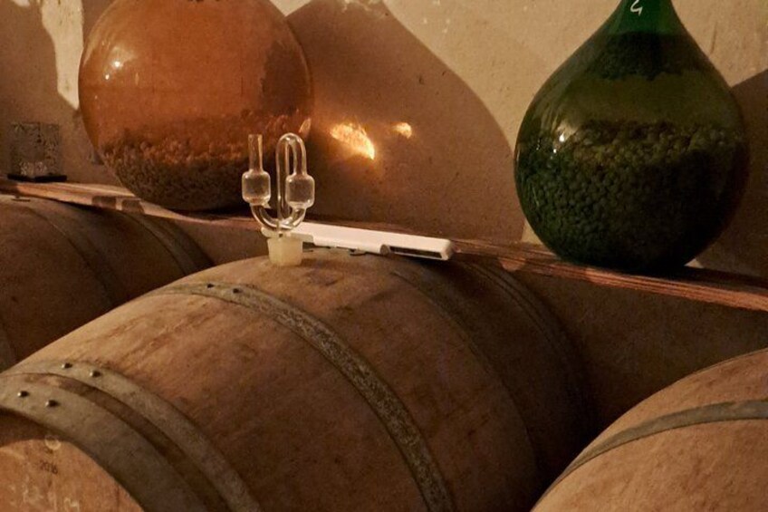 Wooden barrels, a green glass bottle, and a metal container with a white label. 4