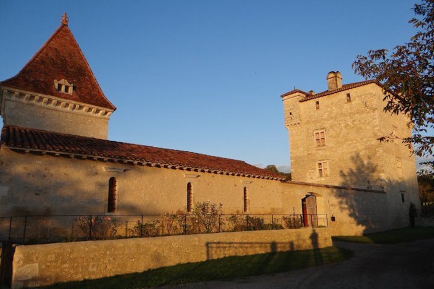 A historic building with a red-tiled roof and a tower. 4