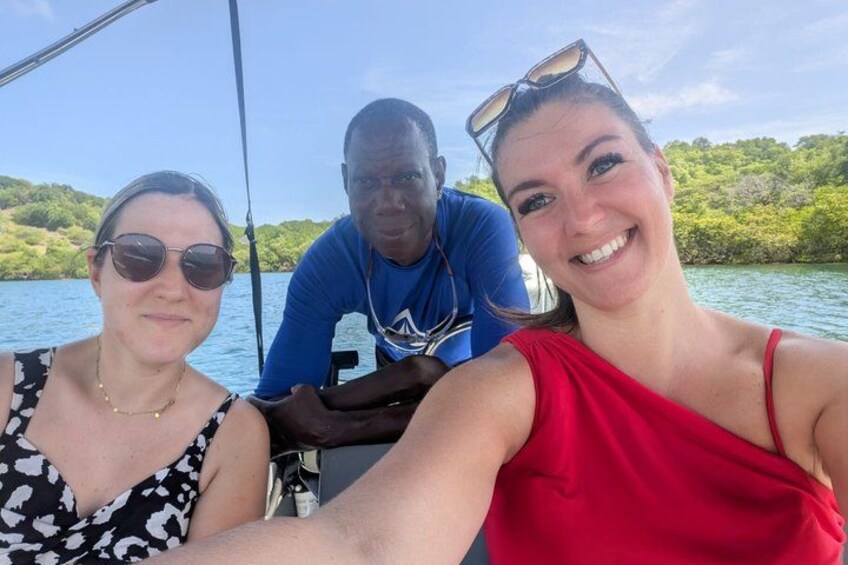 Three people on a boat with a water body and greenery in the background. 4