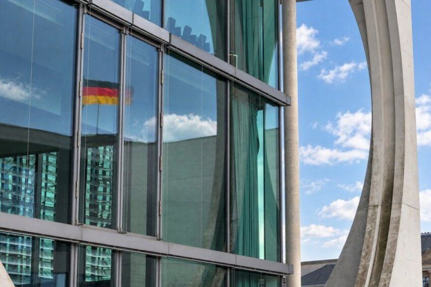 A modern building with large glass windows and a unique curved concrete structure. 2