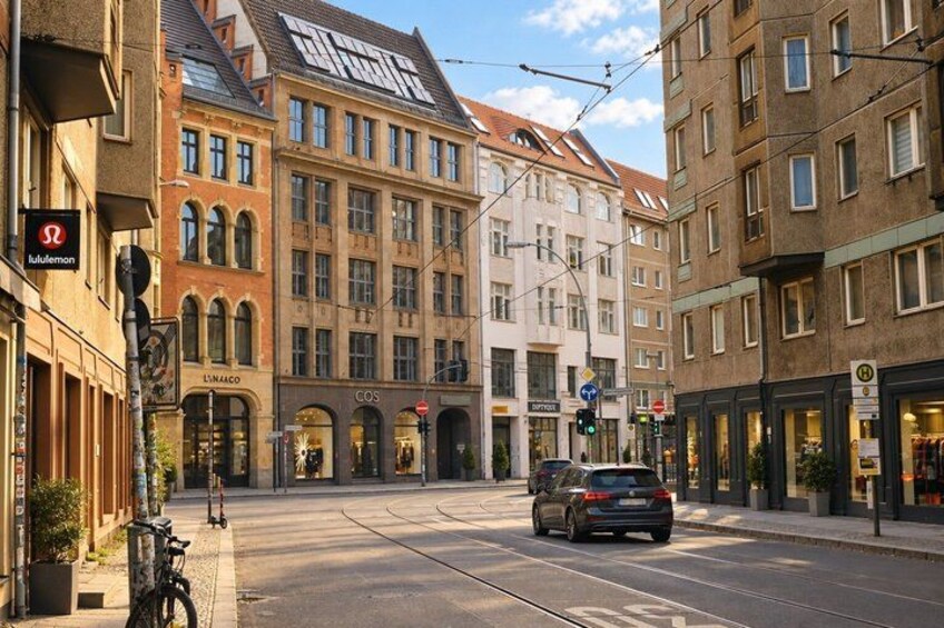 A street with buildings, a tram, and a car. 3