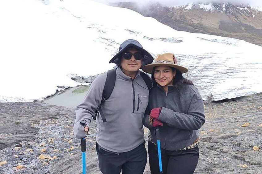 Two people hiking with a glacier in the background. 2