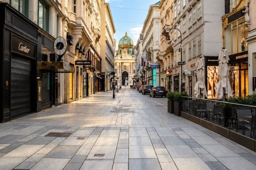 A city street with shops, a clock, and a building with a dome. 3