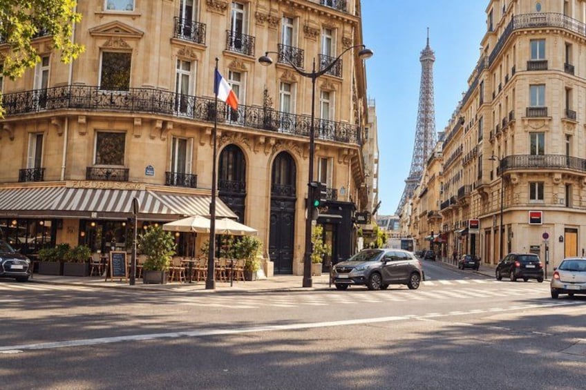 A Parisian street with classic architecture, a café, and the Eiffel Tower in the background. 2